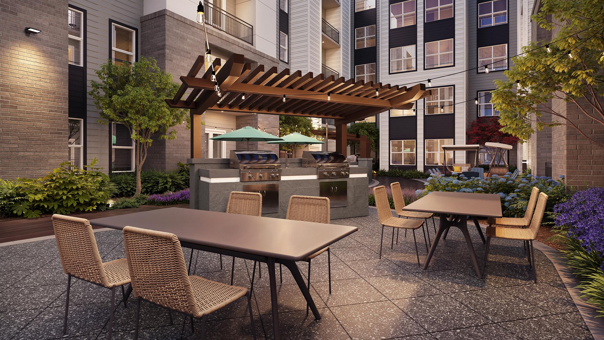 Sterling Tiger Valley Modern outdoor patio with tables, woven chairs, a pergola, grills, greenery, and apartment buildings in the background.