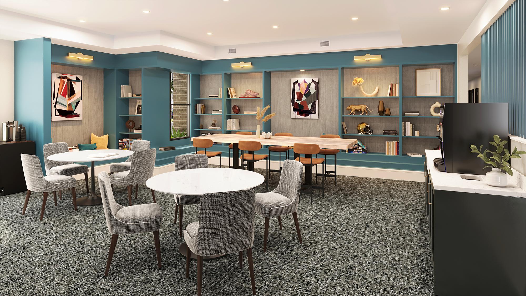 Sterling Tiger Valley Modern lounge with round tables, gray chairs, bookshelves, wall art, a TV, and built-in wooden desk in a brightly lit room.