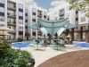 Sterling Tiger Valley Modern apartment courtyard with a pool, shaded seating area, greenery, and multi-story buildings in the background.