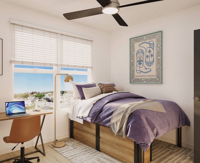 Sterling Tiger Valley A bright dorm room with a bed, desk, chair, laptop, wall art, and window with blinds letting in natural light.